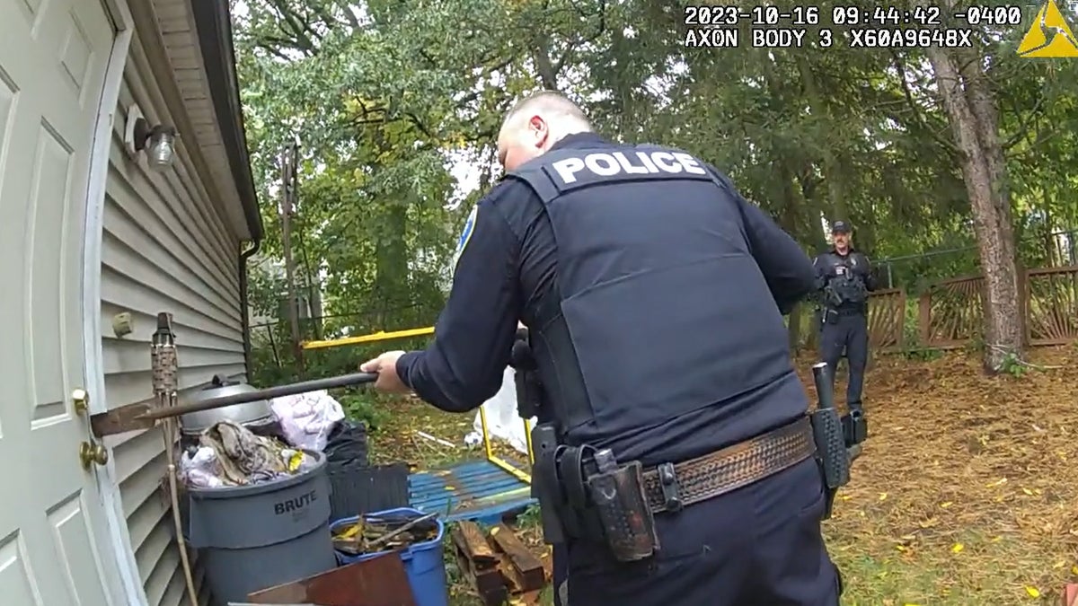 Akron police seen on bodycam using a shovel to pry the shed open.
