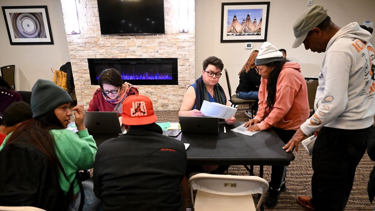 Migrants filling out paperwork in Denver