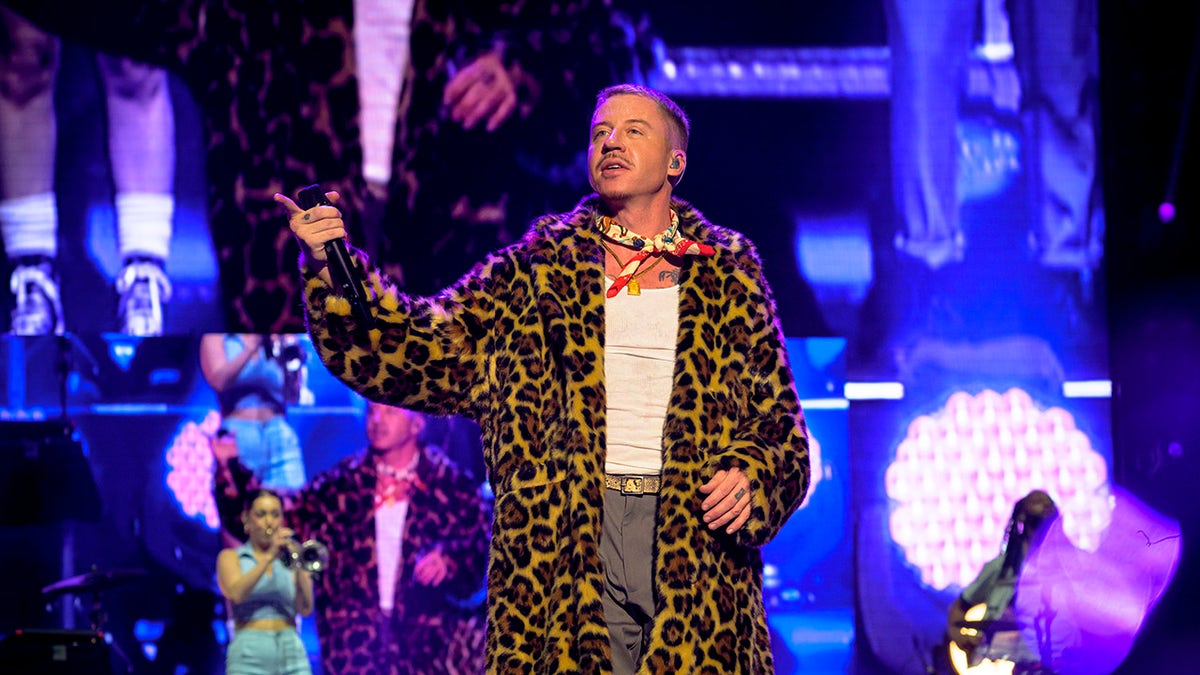 Macklemore performs in faux fur coat