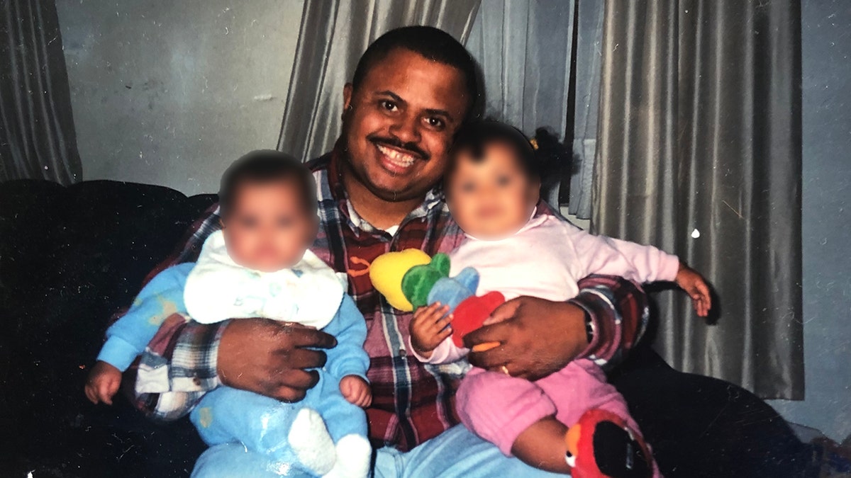 Michael Beverly holding two children.