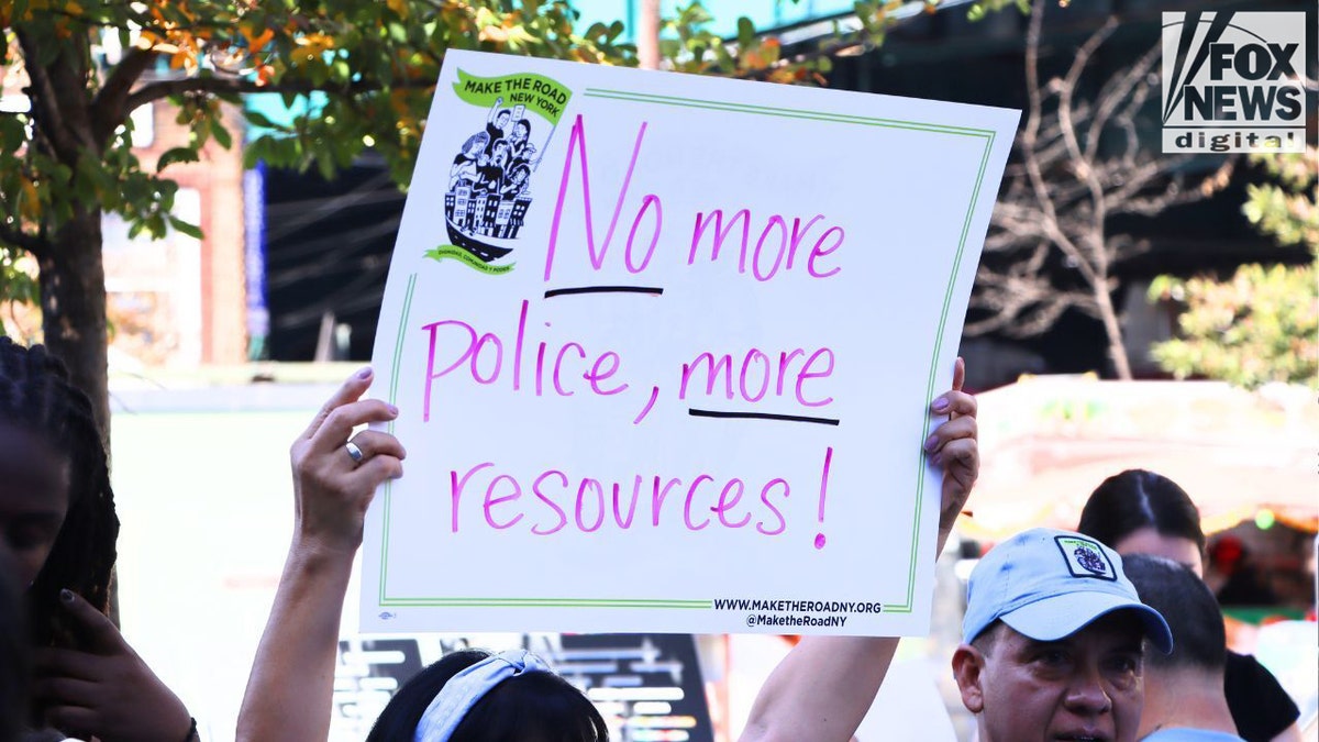 A sign reading "No more police, more resources."