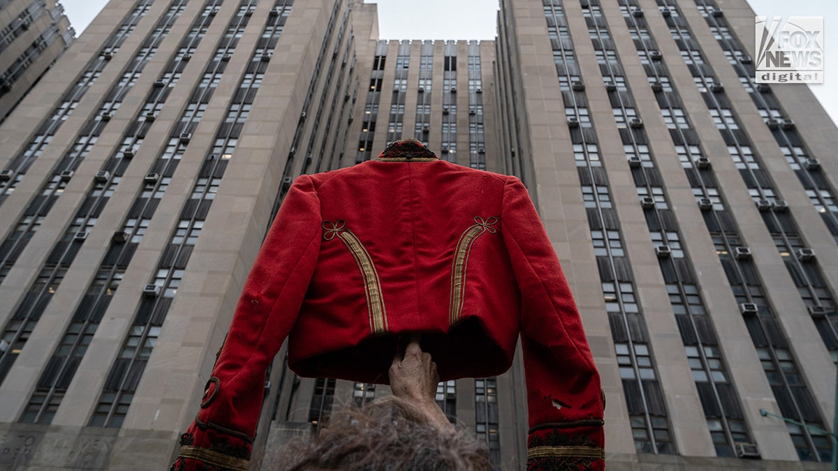 Demonstrators hold up a Michael Jackson-style jacket to represent Jordan Neely as Daniel Penny arrives for his trial