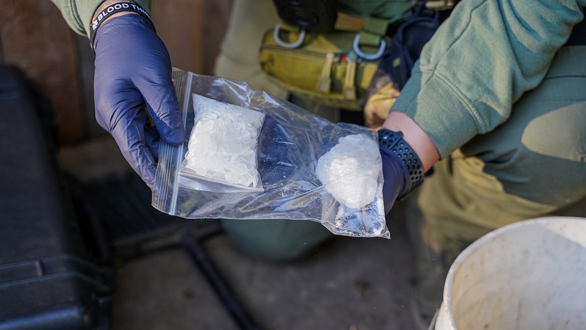 An Oxford Police officer holding a bag of drugs.