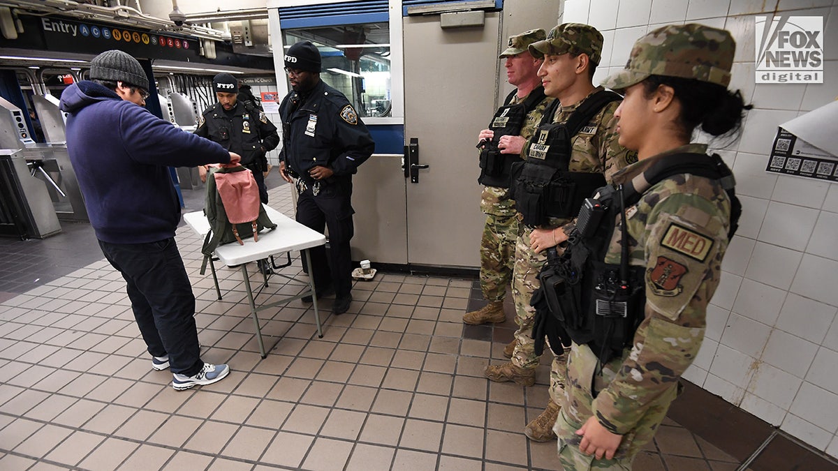 Members of the NYPD and National Guard conduct randomized bag searches in New York City’s subway system