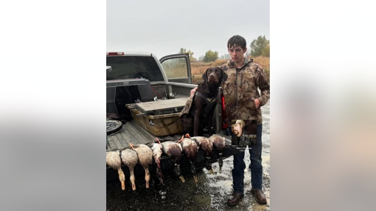 Andruw Cornett poses with a dog and birds in the bed of a pickup truck