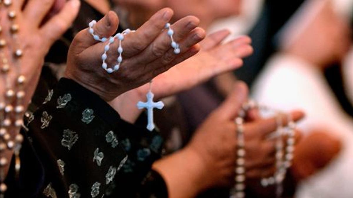 BAGHDAD, IRAQ - APRIL 7: Worshippers pray at a service for Pope John Paul II on April, 7, 2005 at a Catholic church in Baghdad, Iraq. Pope John Paul II died at his residence in the Vatican on April 2, aged 84 years old. His funeral will be held in St. Peter's Square on Friday, April 8. Cardinals under the age of 80 will start the conclave on April 18, where a new Pope will be chosen. (Photo by Wathiq Khuzaie/Getty Images)