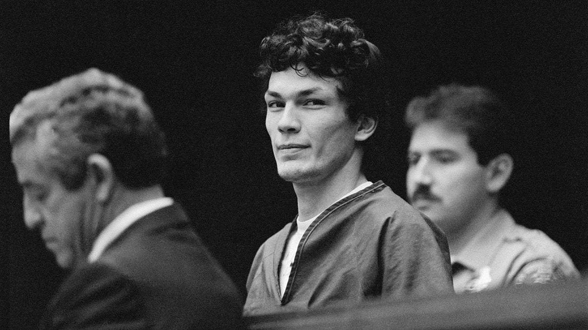 Richard Ramirez sneering in between two men in court