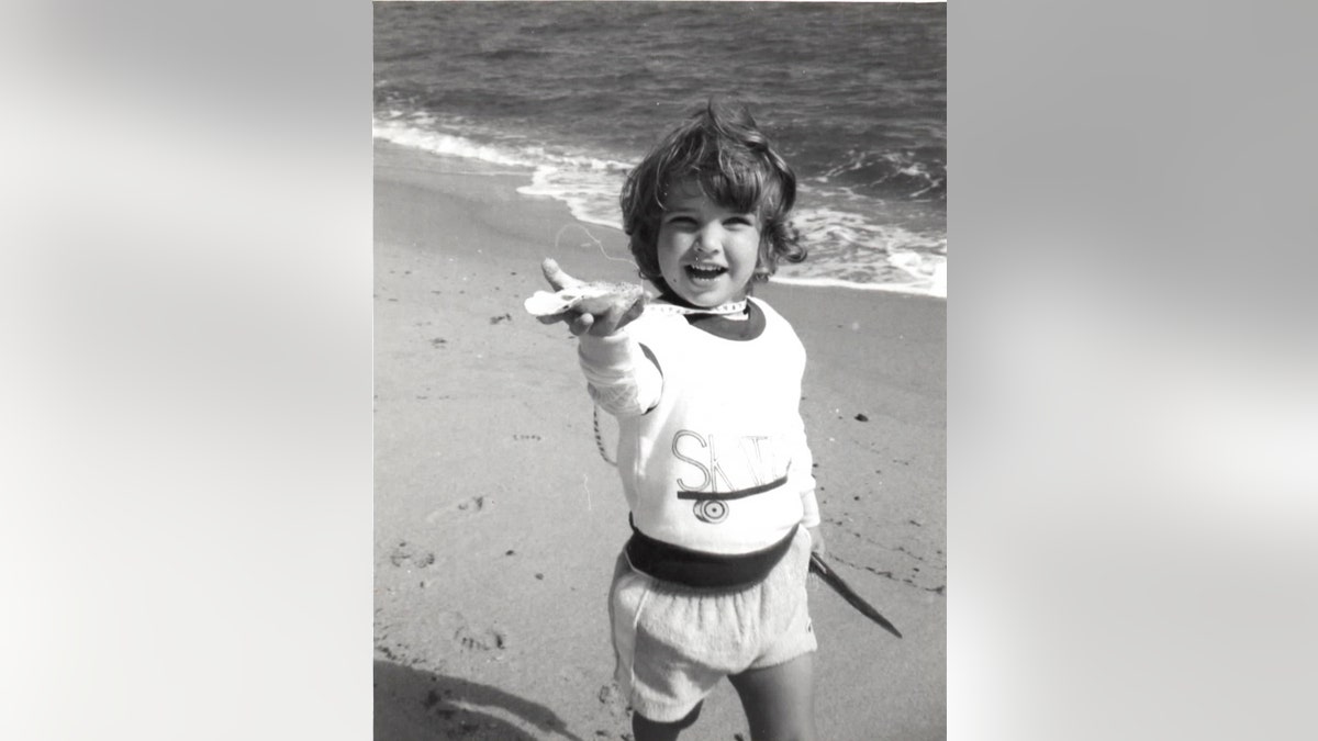 A black and white photo of Collier Landry on the beach smiling.