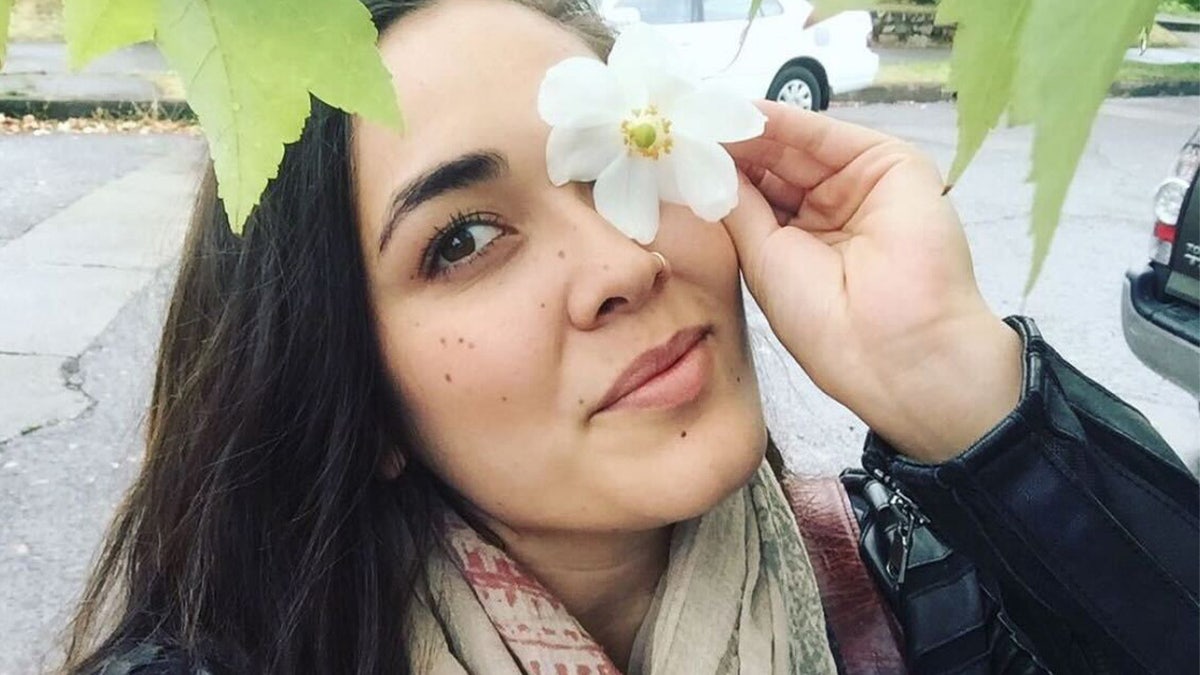 Hannah Kobayashi holding a flower to her face