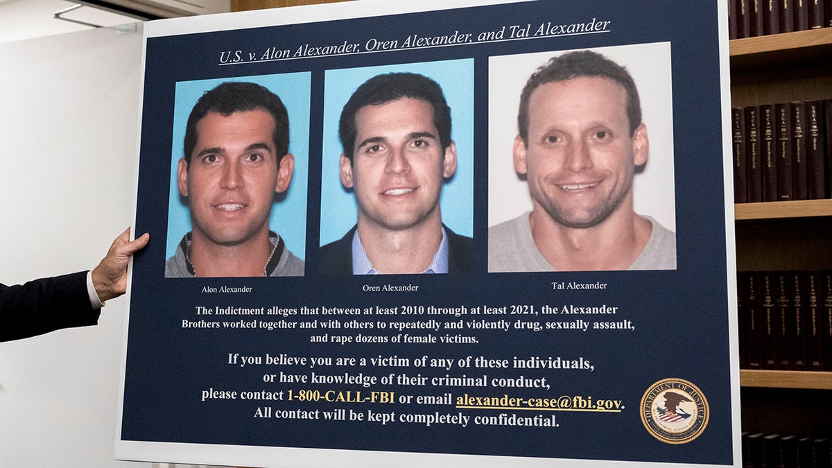 A display showing images of Alon, Oren, and Tal Alexander prior to a news conference in New York