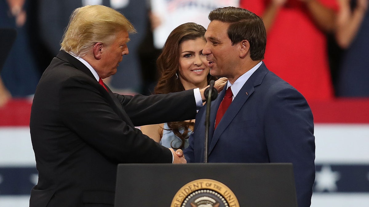 Donald Trump and Ron DeSantis shake hands