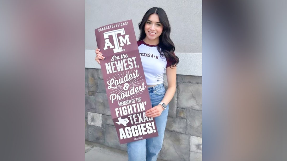 Brianna Aguilera holds a sign congratulating her on her acceptance to Texas A&amp;M.