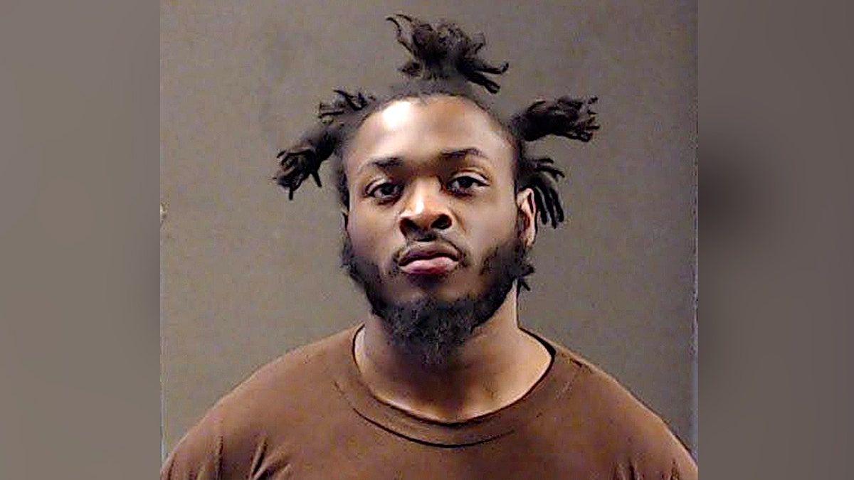 mugshot of man in brown shirt