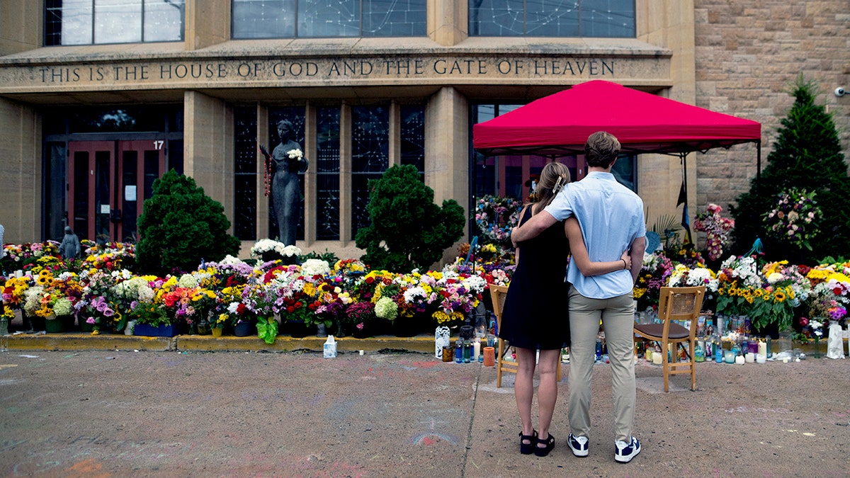 Couple standing in front of Annunciation Church and School.