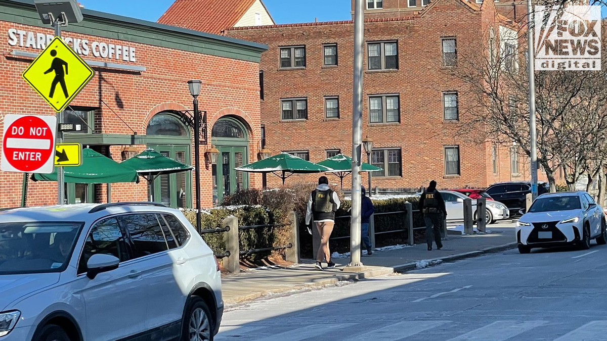 FBI agents canvas an area outside a Starbucks store near Brown University
