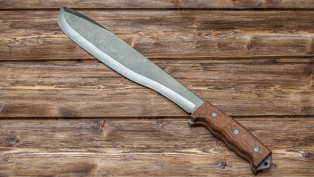 A machete against a wood background