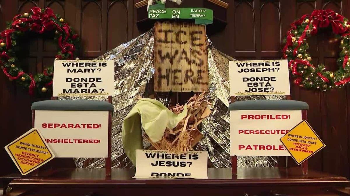 Outdoor nativity with Mary, Joseph, and Jesus figures inside a fenced enclosure.