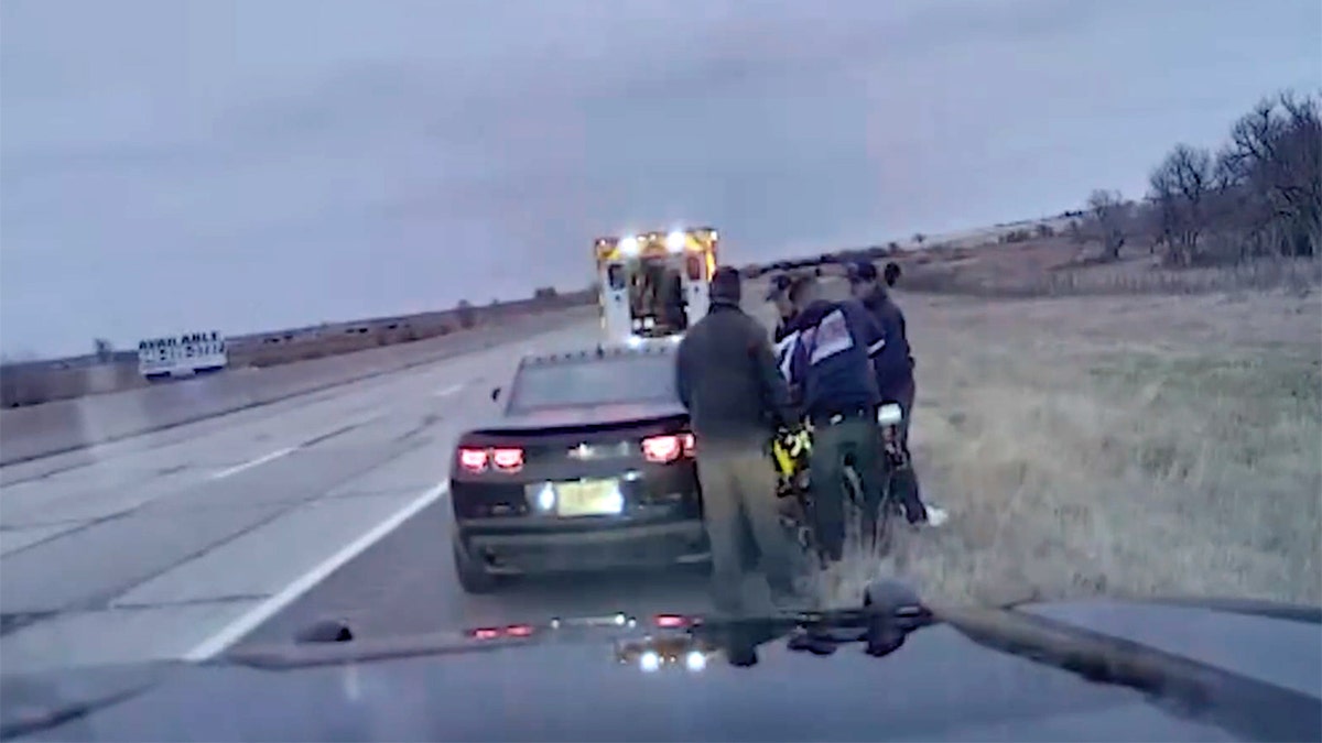 Trooper helping woman give birth in car.