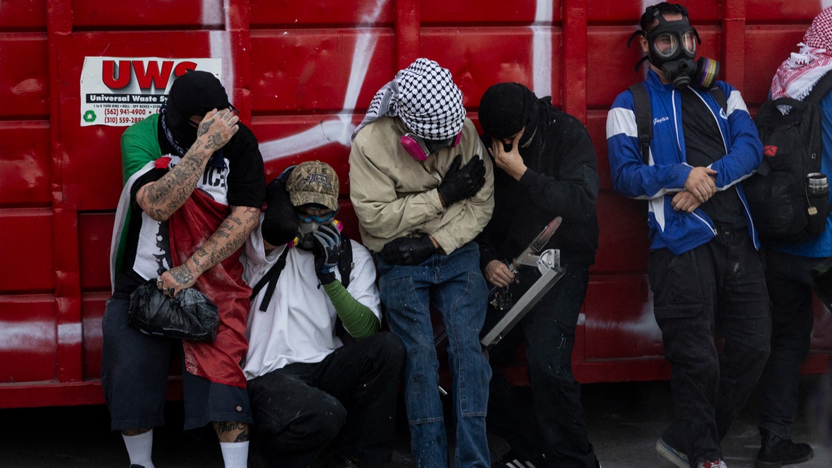 Anti-ICE protesters wearing gas masks and PPI