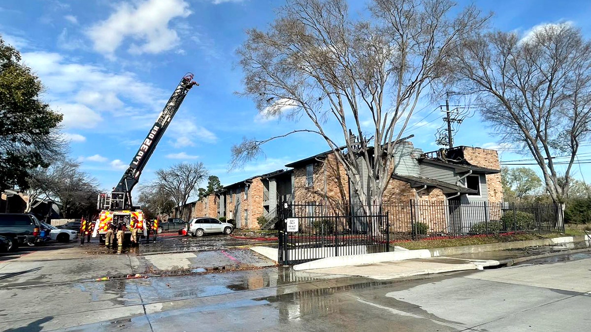 fire truck ladder near burned apartment complex