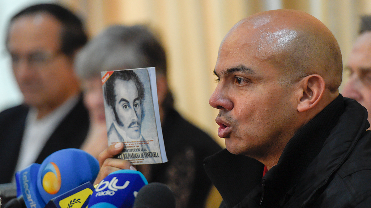 Retired Venezuelan army general Cliver Alcala holds up a book while speaking at a press conference in an archive photo