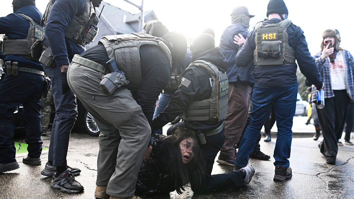 ICE agents make an arrest of a woman