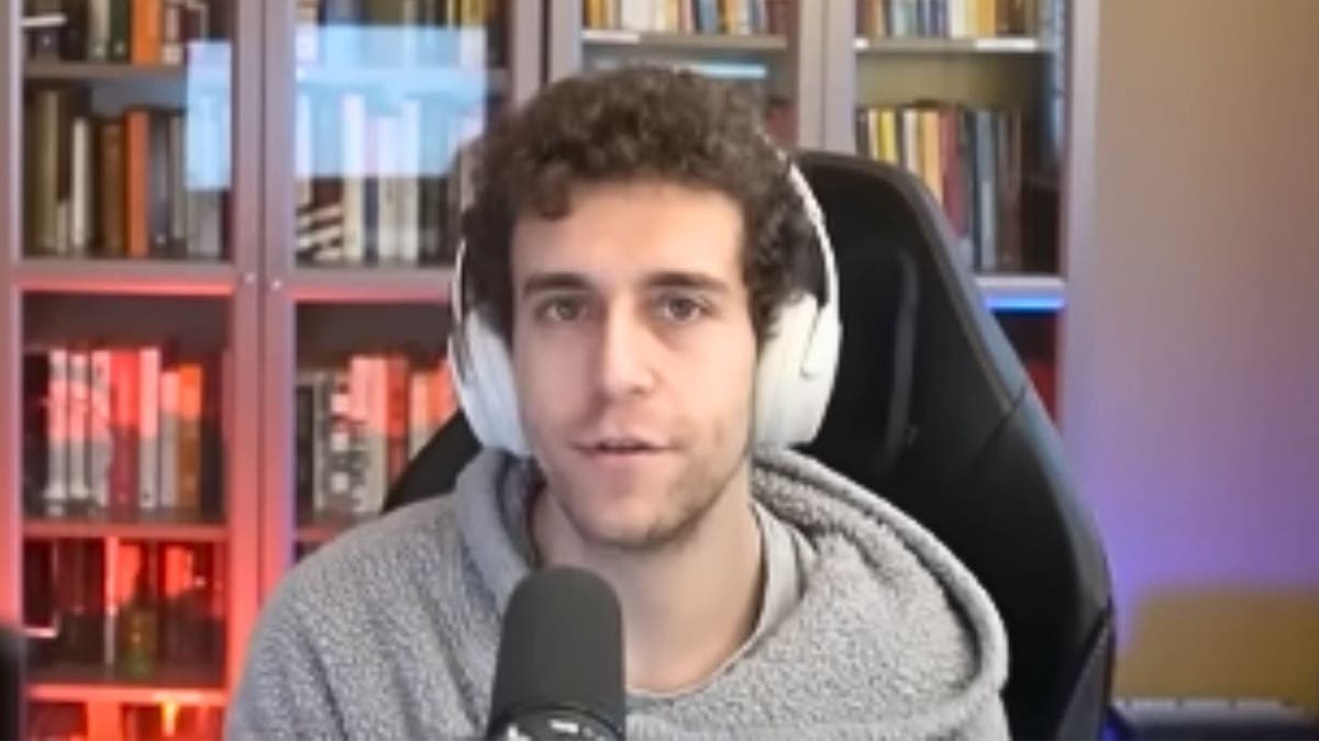 Daniel Naroditsky speaks into a microphone during an online chess livestream