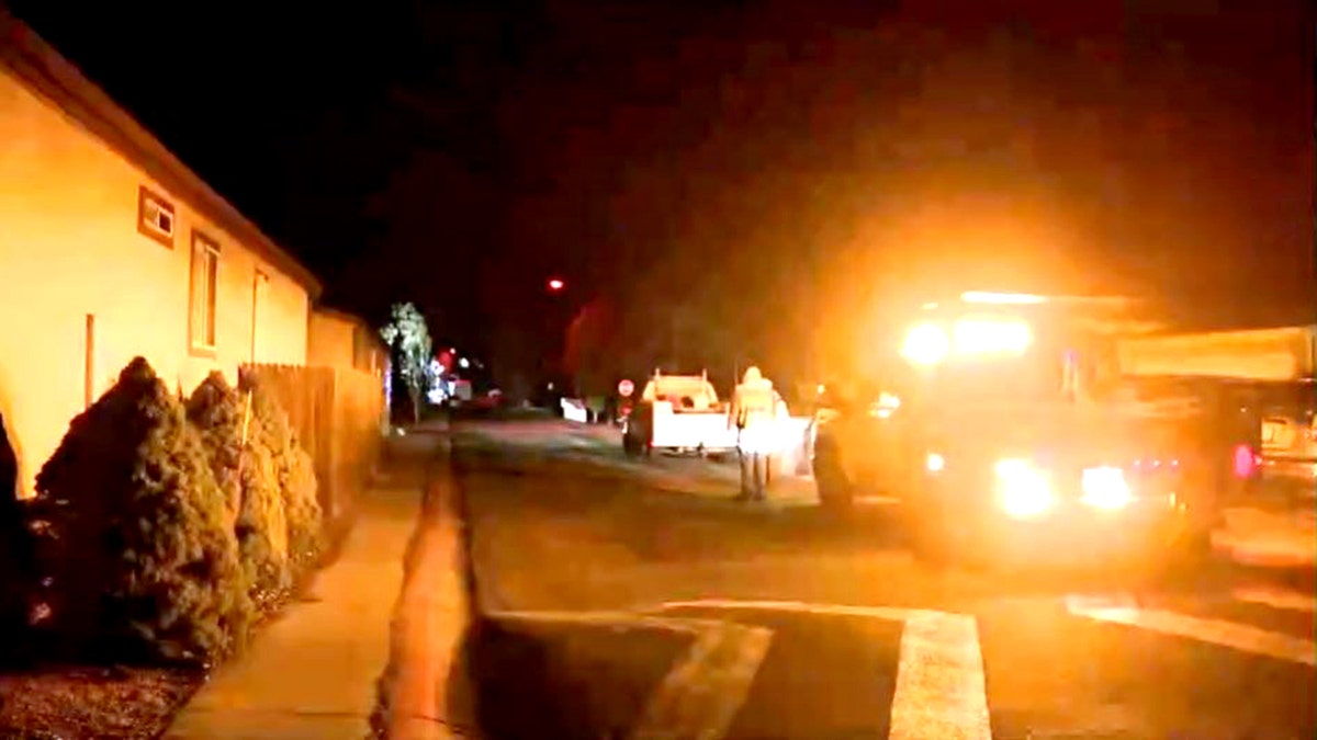 workers on road near shooting scene