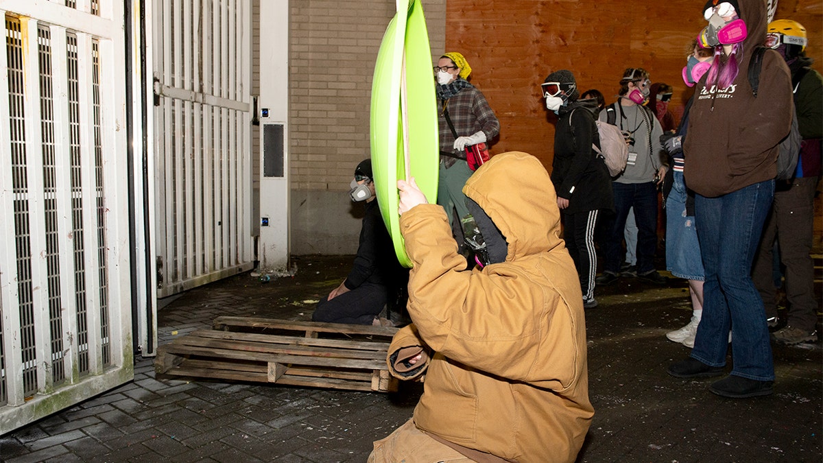 Law enforcement fires crowd-control munitions as demonstrators gather near a federal immigration building.