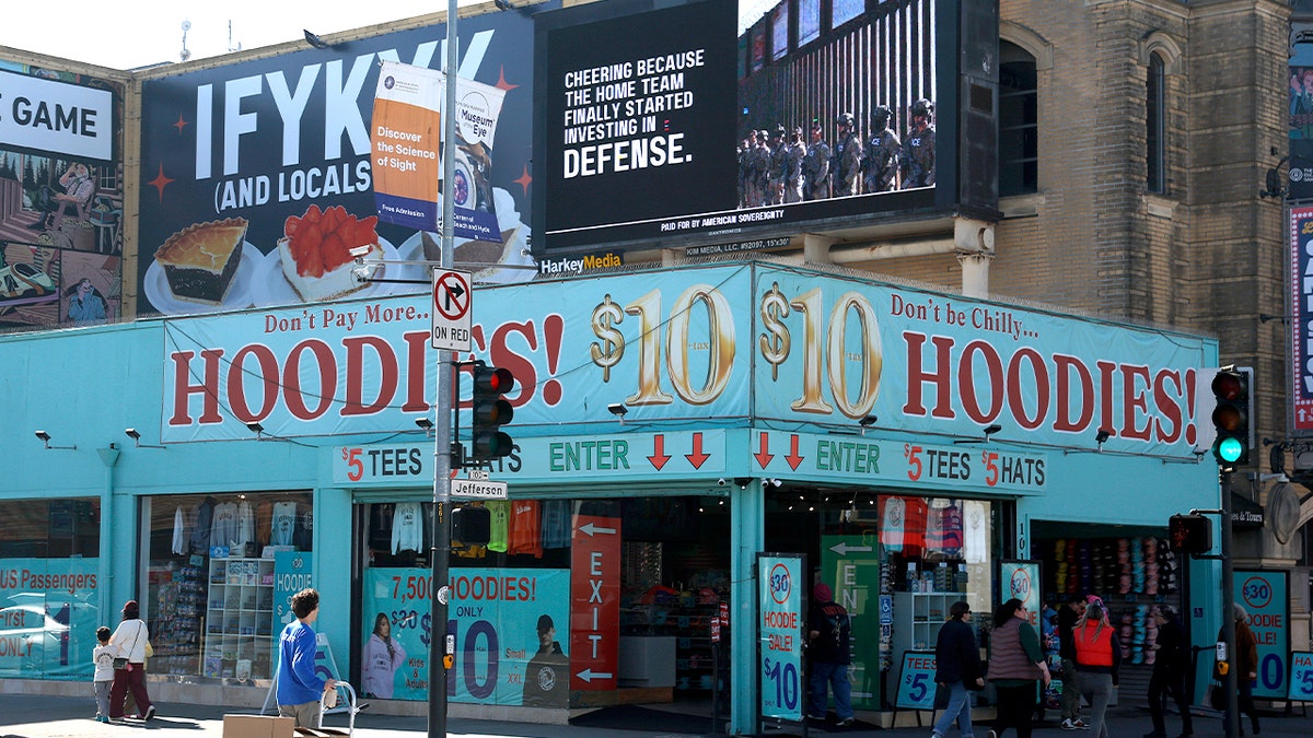 billboard says "cheering because the home team finally started investing in defense."