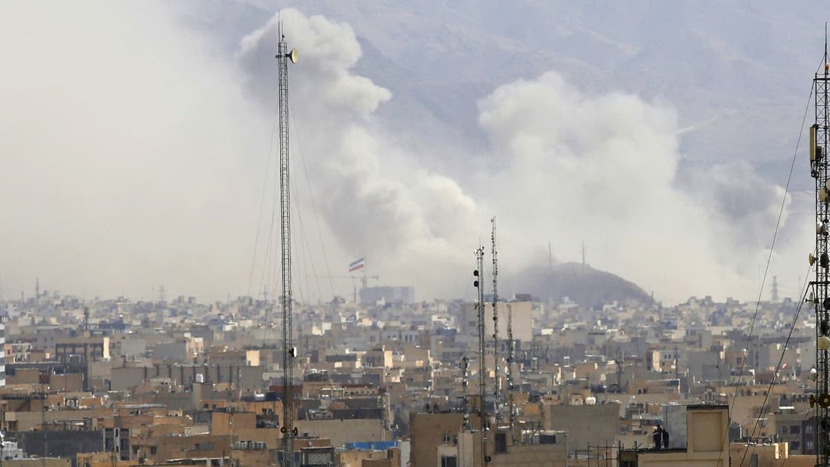 Thick smoke billows over buildings in Tehran following Israeli airstrikes.