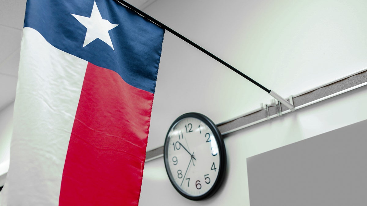 Texas high school or university classroom with focus on state flag and clock.