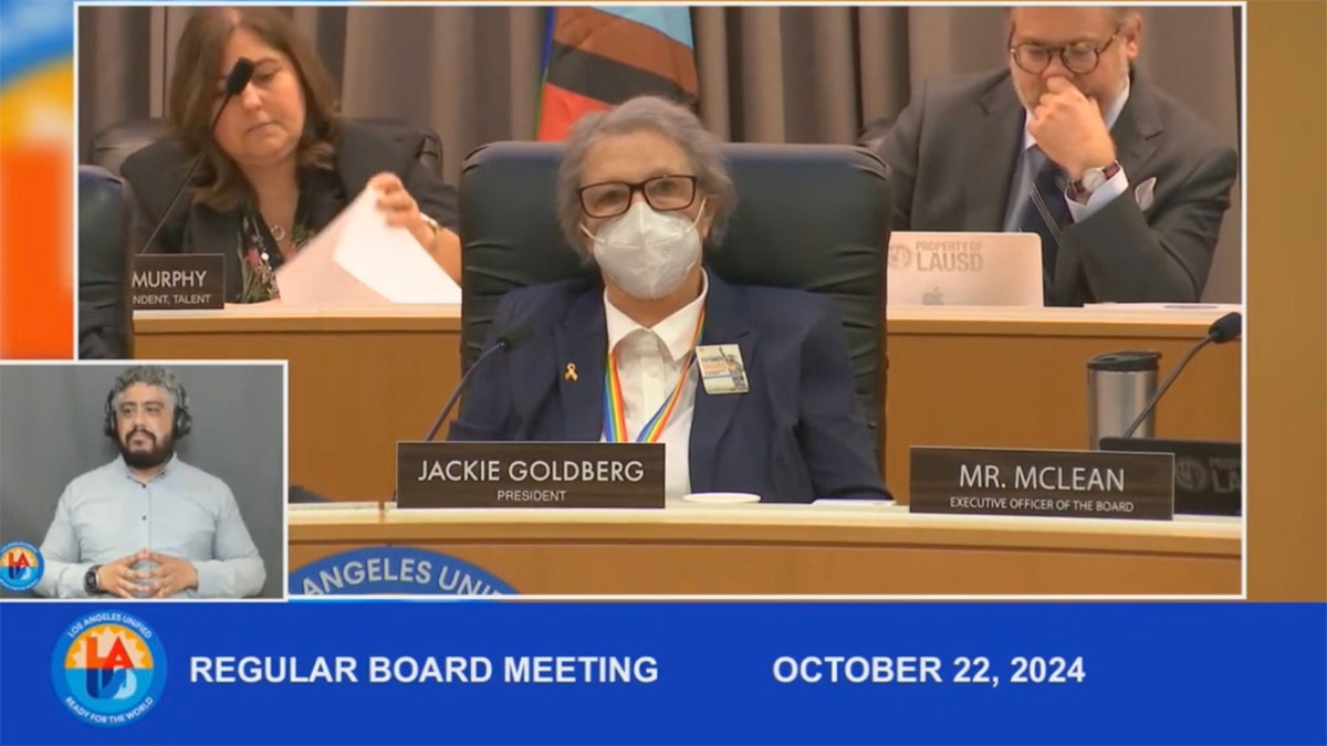 LAUSD Board Member sits in meeting wearing COVID mash and lgbt lanyard