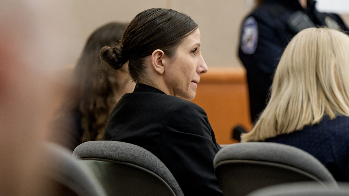 Kouri Richins looking toward a courtroom during a legal proceeding.