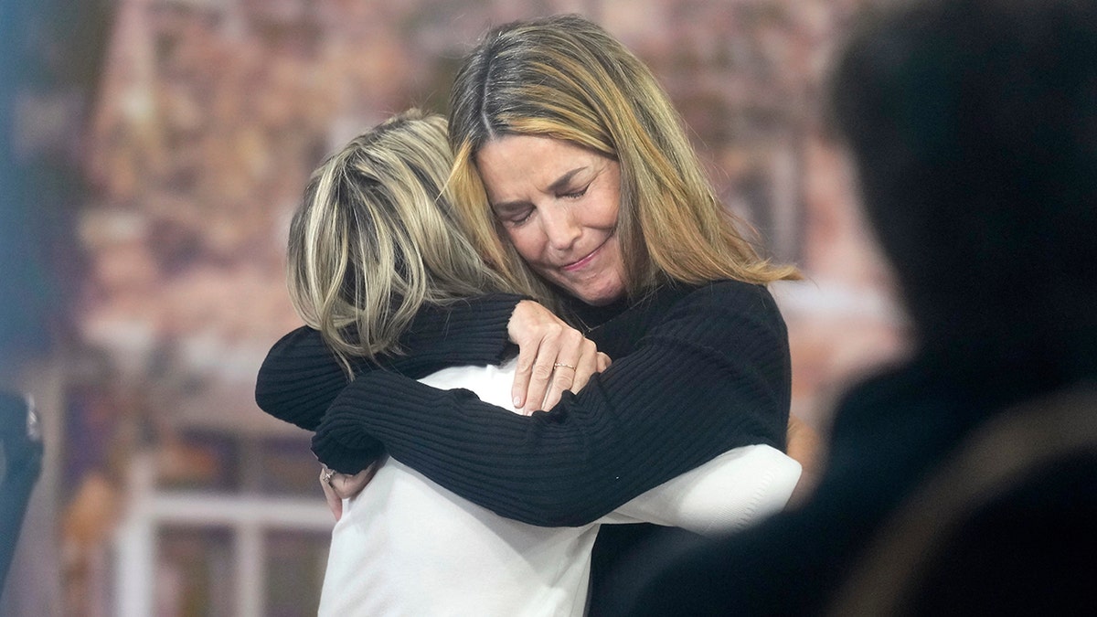 Savannah Guthrie hugs Dylan Dreyer on the Today show set at Rockefeller Plaza.