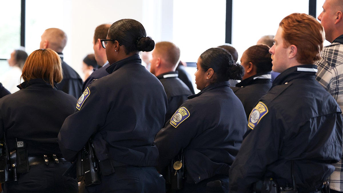 Officers in uniform stand in support of Nicholas O'Malley