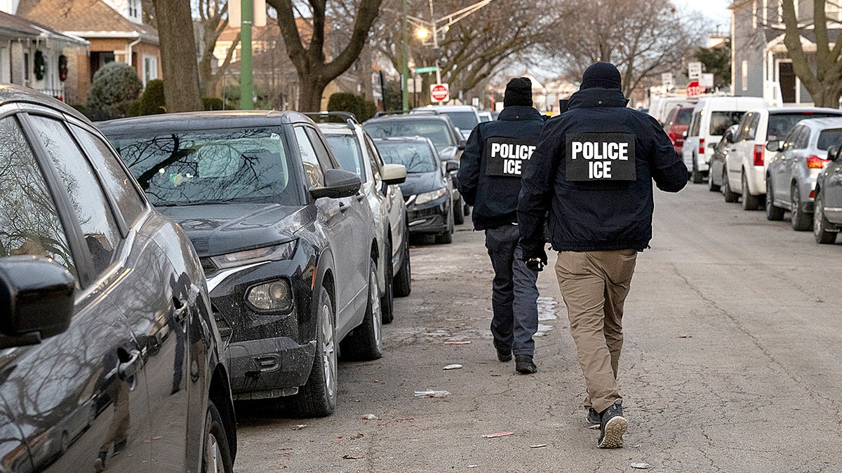 ICE agents walking down a street in Chicago during enforcement operation