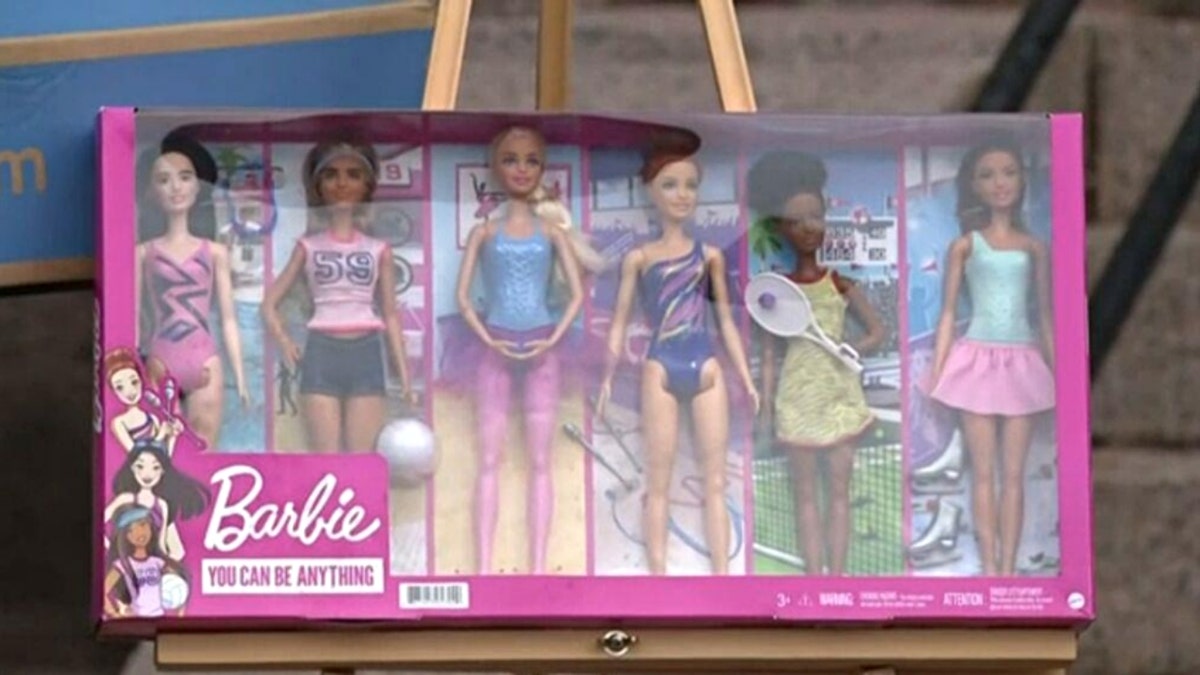 Former FedEx delivery driver Tanner Horner holding a box of Barbies outside a home