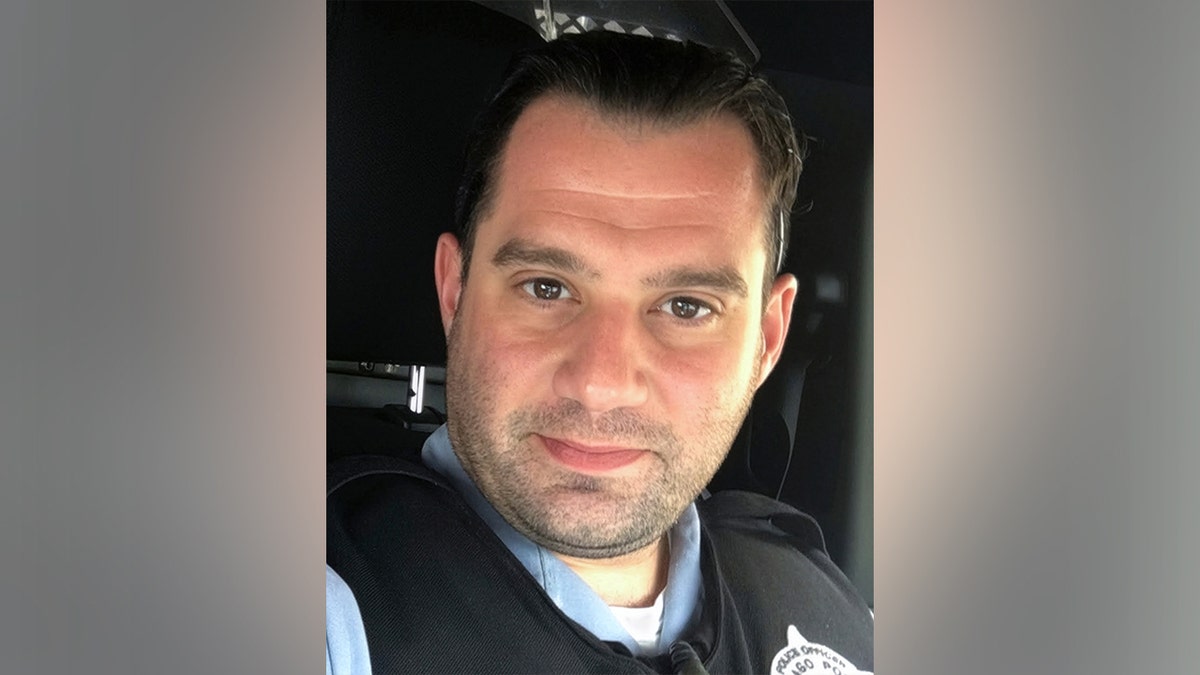 John Bartholomew standing and smiling against a plain background