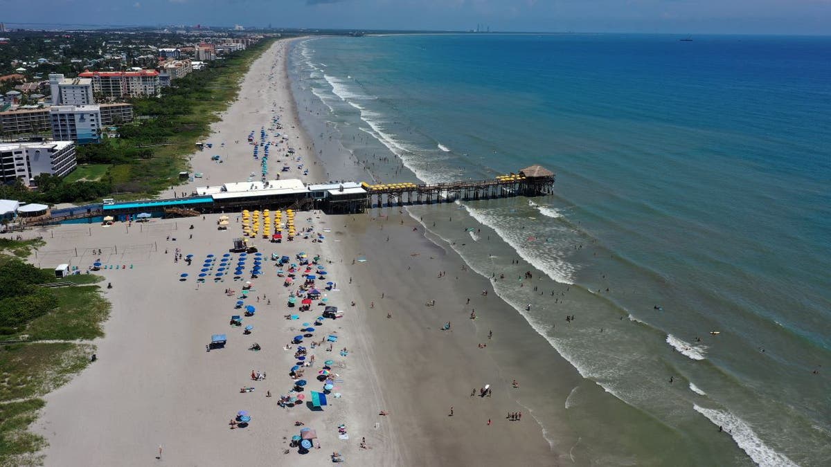 Aerial view of beachgoers near the pier at Cocoa Beach Florida