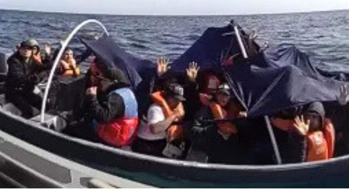 13 people are packed into a small boat on the Pacific Ocean