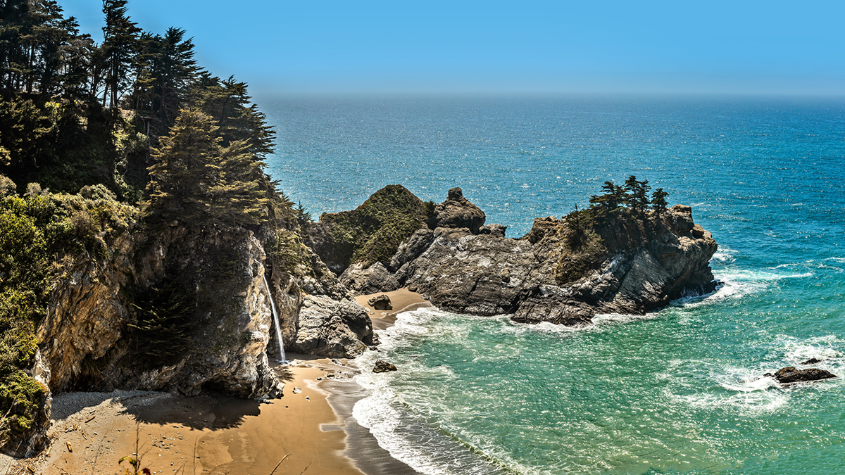 A scenic view of Big Sur coastline with camping tents set up near the shore.
