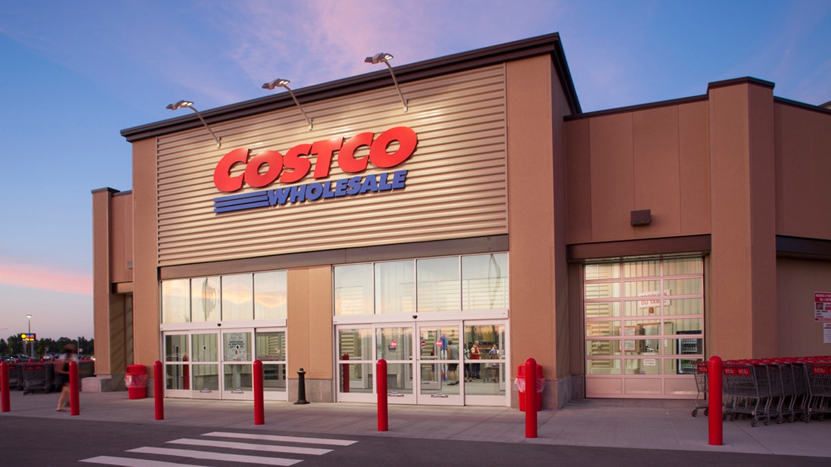 Costco storefront seen from parking lot with pink and blue sky in background
