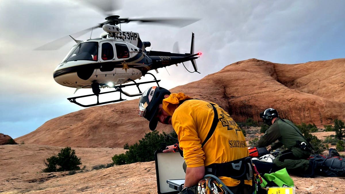 rescue team on ground and helicopter flying above