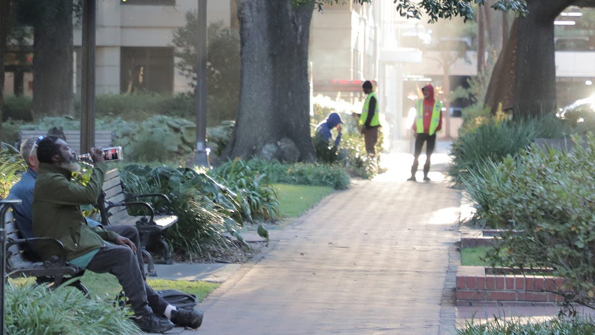 Unhoused people sit on benches in Savannah, Georgia.