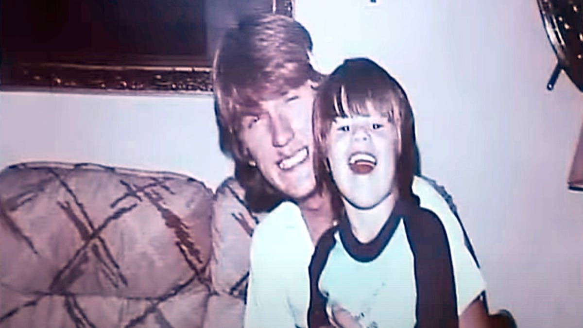 An old photograph of a smiling Timothy Jones Sr. holding his laughing son Timothy Jones Jr.