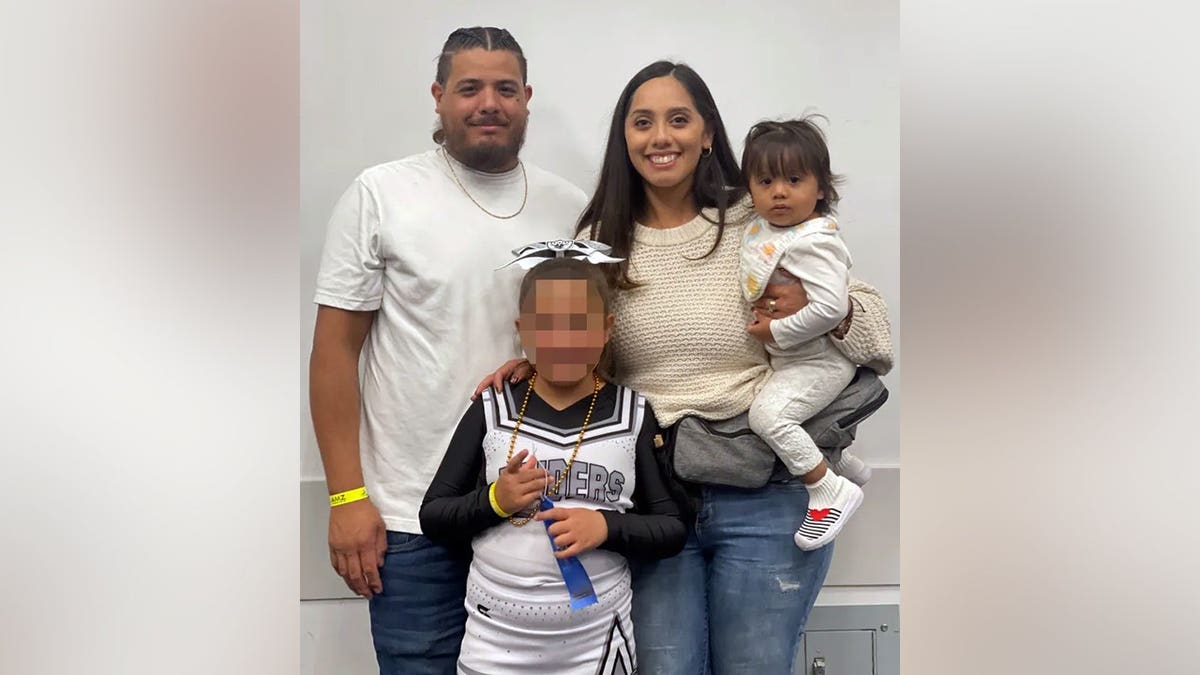 Anna, her parents and older sister pose for a picture