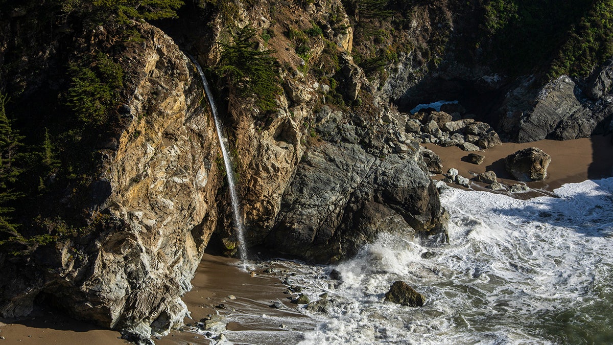 McWay Falls cascading over an 80-foot cliff onto a beach at Julia Pfeiffer Burns State Park