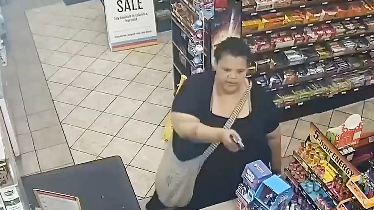 Woman points gun at employee in a gas station