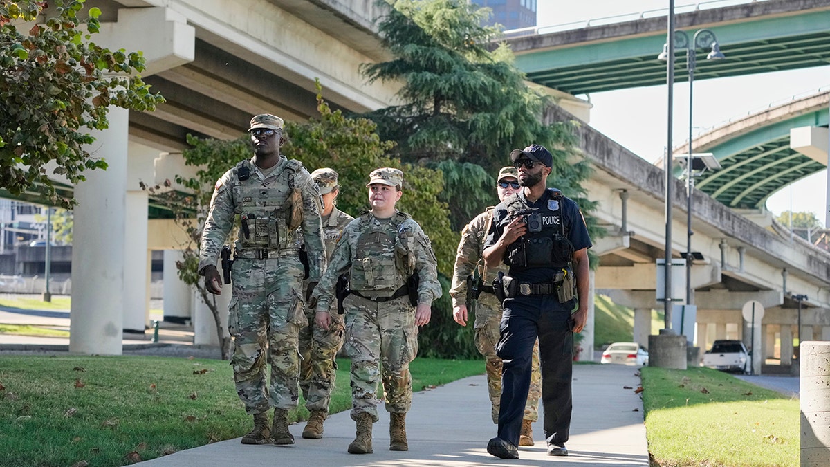 Memphis Police Department officer patrolling with National Guard members on a street
